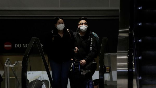 Travellers wearing masks arrive on a direct flight from China, after a spokesman from the U.S. Centers for Disease Control and Prevention (CDC) said a traveller from China had been the first person in the United States to be diagnosed with the Wuhan coronavirus, at Seattle-Tacoma International Airport in SeaTac, Washington, U.S. January 23, 2020 - Sputnik International