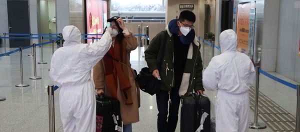 Workers in protective suits check the temperature of passengers arriving at the Xianning North Station on the eve of the Chinese Lunar New Year celebrations, in Xianning, a city bordering Wuhan to the north, in Hubei province, China January 24, 2020 Workers in protective suits check the temperature of passengers arriving at the Xianning North Station on the eve of the Chinese Lunar New Year celebrations, in Xianning, a city bordering Wuhan to the north, in Hubei province, China January 24, 2020 - Sputnik International
