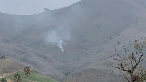 Smoke rises amid foggy weather from the site of a helicopter crash that killed former NBA star Kobe Bryant, his daughter Gianna and seven others, along a hillside in Calabasas, California, U.S., January 26, 2020 - Sputnik International