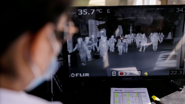 Airport personnel monitor a thermal scanner as passengers arrive at the Ninoy Aquino International Airport in Pasay - Sputnik International
