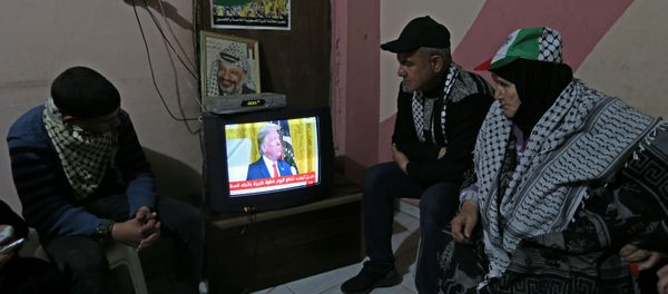 Palestinians watch a television broadcasting the announcement of Mideast peace plan by U.S. President Donald Trump, in the southern Gaza Strip January 28, 2020. REUTERS/Ibraheem Abu Mustafa - Sputnik International