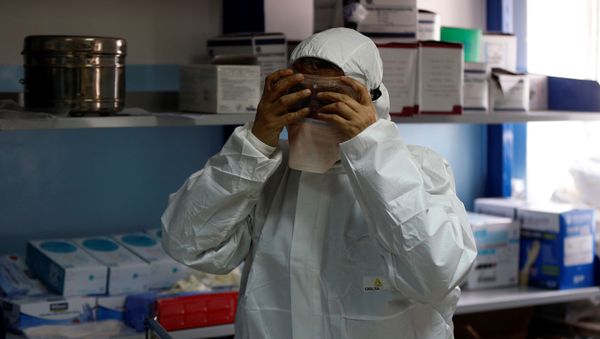 A member of the medical staff puts on protective gear at a new section specialised in receiving any person who may have been infected with coronavirus, at the Al-Bashir Governmental Hospital in Amman, Jordan January 28, 2020 - Sputnik International