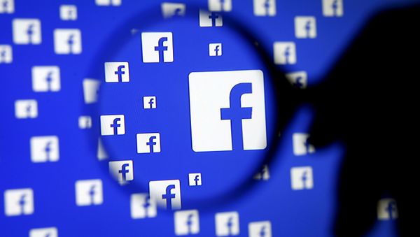 A man poses with a magnifier in front of a Facebook logo on display in this illustration taken in Sarajevo, Bosnia and Herzegovina, December 16, 2015 - Sputnik International