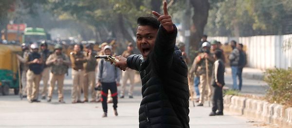 An unidentified man reacts as he brandishes a gun during a protest against a new citizenship law outside the Jamia Millia Islamia university in New Delhi, India, January 30, 2020 - Sputnik International