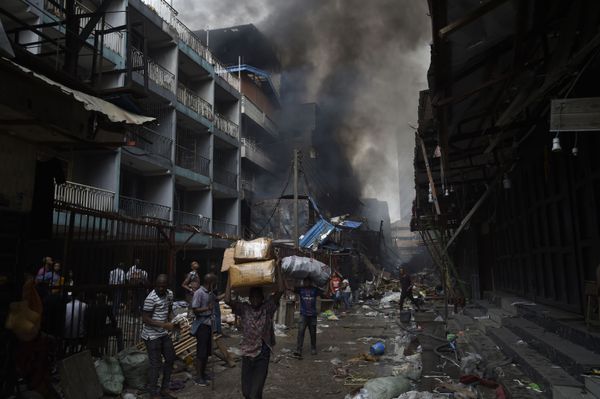 People carry goods salvaged from a fire that broke out in a section of the Balogun market in Lagos on January 29, 2020. - Sputnik International