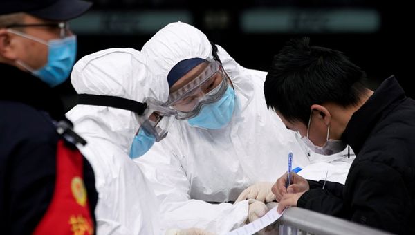Staff members wearing protective masks check a passenger at Shanghai railway station in Shanghai, China, as the country is hit by an outbreak of a new coronavirus, February 2, 2020. - Sputnik International