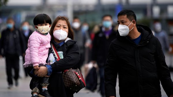 Passengers wearing masks walk outside the Shanghai railway station in Shanghai, China, as the country is hit by an outbreak of a new coronavirus, February 2, 2020. - Sputnik International