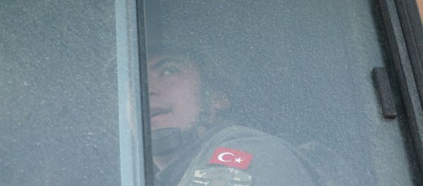 A Turkish military personnel looks out the window of a military vehicle as it enters the Bab al-Hawa crossing at the Syrian-Turkish border, in Idlib governorate, Syria, February 9, 2020 - Sputnik International