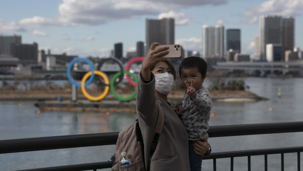 A Japanese woman and her son in front of the Olympics sign in Tokyo - Sputnik International
