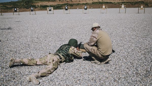 In this March 9, 2016 file image, a Dutch army trainer, right, helps a Kurdish Peshmerga soldier during a military training session at a shooting range, at Bnaslawa Military Base in Irbil, northern Iraq.  - Sputnik International