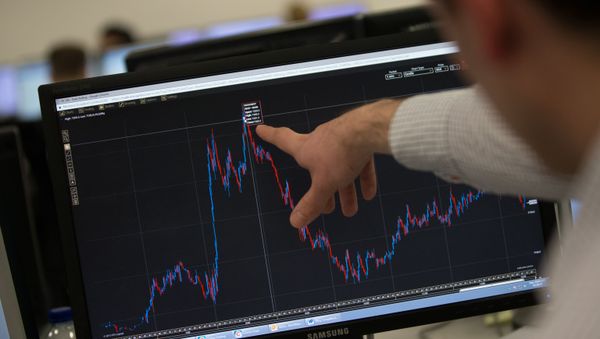 A trader points to a trading screen displaying today's record high for the FTSE 100, at ETX Capital in central London, England (File) - Sputnik International