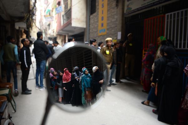 Voters are seen reflected on a mirror as they queue at a polling station to cast their votes during the Legislative Assembly elections in New Delhi on February 8, 2020. Voters are seen reflected on a mirror as they queue at a polling station to cast their votes during the Legislative Assembly elections in New Delhi on February 8, 2020. - Sputnik International