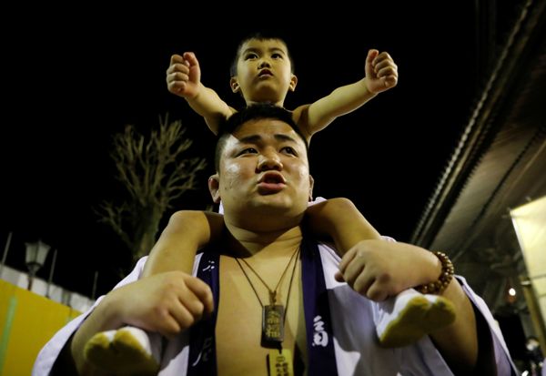 A man carries a boy on his shoulders during a naked festival where men dressed in loincloths try to snatch a wooden stick A man carries a boy on his shoulders during a naked festival where men dressed in loincloths try to snatch a wooden stick - Sputnik International