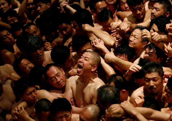 Men dressed in loincloths react as a priest splashes water on them before they prepare to snatch a wooden stick Men dressed in loincloths react as a priest splashes water on them before they prepare to snatch a wooden stick - Sputnik International