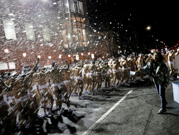 A woman splashes water on men dressed in loincloths before they attend a naked festival A woman splashes water on men dressed in loincloths before they attend a naked festival - Sputnik International