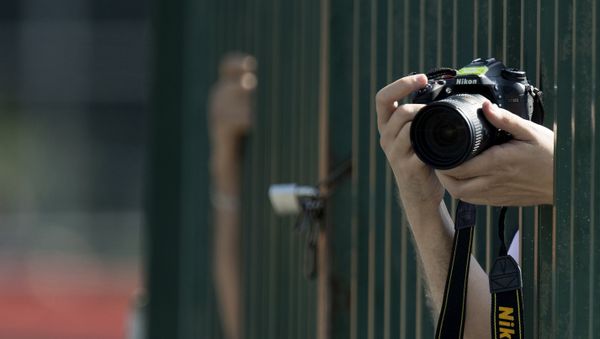 A photographer takes pictures with a Nikon D7100 camera during the third practice session at the Spa-Francorchamps circuit in Spa on August 27, 2016 ahead of the Belgian Formula One Grand Prix - Sputnik International