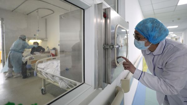 A medical worker calls his colleague inside an isolated ward at Jinyintan Hospital in Wuhan, the epicentre of the novel coronavirus outbreak, in Hubei province, China February 13, 2020. - Sputnik International