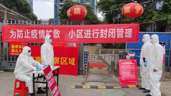 Workers in protective suits are seen at a checkpoint for registration and body temperature measurement, at an entrance to a residential compound in Wuhan, February 13, 2020 - Sputnik International