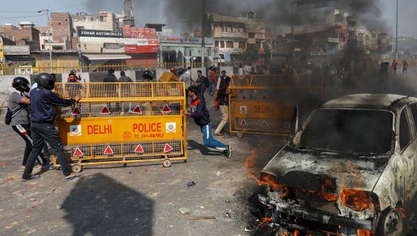 People supporting a new citizenship law push police barricades during a clash with those opposing the law in New Delhi, India, 24 February 2020 - Sputnik International