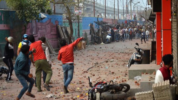 People supporting a new citizenship law and those opposing the law, throw stones at each other during a clash in Maujpur area of New Delhi, India, February 23, 2020 - Sputnik International