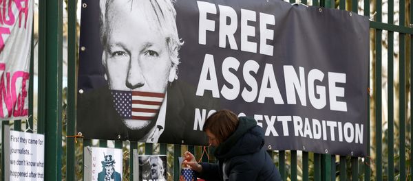A supporter of WikiLeaks founder Julian Assange posts a sign on the Woolwich Crown Court fence, ahead of a hearing to decide whether Assange should be extradited to the United States, in London, Britain February 25, 2020. - Sputnik International