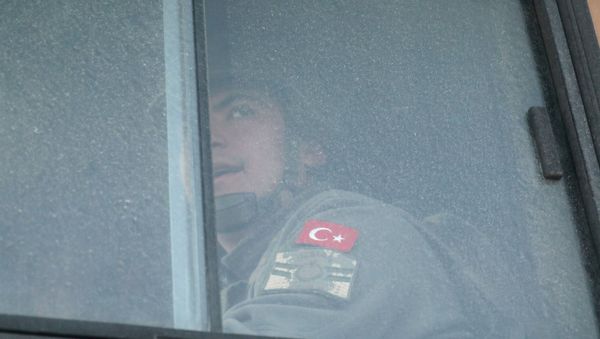 A Turkish military personnel looks out the window of a military vehicle as it enters the Bab al-Hawa crossing at the Syrian-Turkish border, in Idlib governorate, Syria, February 9, 2020. REUTERS/Khalil Ashawi     TPX IMAGES OF THE DAY - Sputnik International