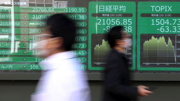 People wearing protective face masks, following an outbreak of the coronavirus, walk past a screen showing Nikkei index, outside a brokerage in Tokyo, Japan February 28, 2020. - Sputnik International