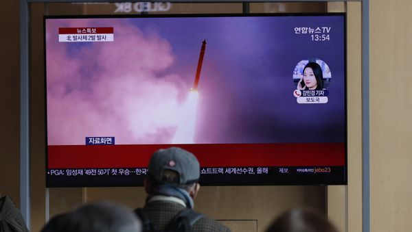 People watch a TV screen showing a news program reporting about North Korea's firing of projectiles with a file image at the Seoul Railway Station in Seoul - Sputnik International