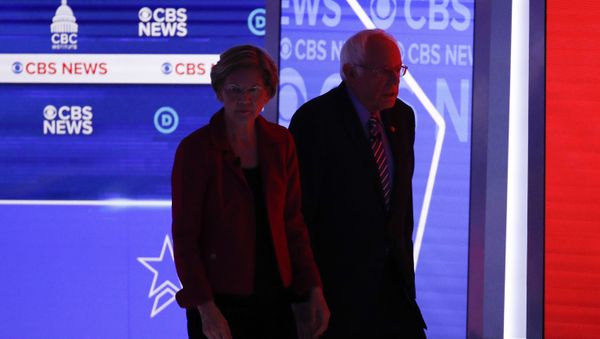 Democratic presidential candidates, Sen. Elizabeth Warren, D-Mass., left, and Sen. Bernie Sanders, I-Vt., right, walks off the stage during a commercial break as they participate in a Democratic presidential primary debate at the Gaillard Center, Tuesday, Feb. 25, 2020, in Charleston, S.C., co-hosted by CBS News and the Congressional Black Caucus Institute. - Sputnik International