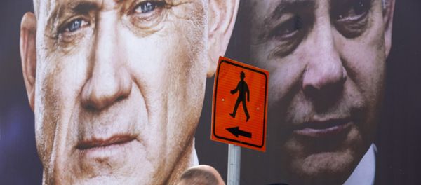 People walk past an election campaign billboard for the Blue and White party, the opposition party led by Benny Gantz, left, in Ramat Gan, Israel, Sunday, Feb. 23, 2020. Prime Minister Benjamin Netanyahu of the Likud party is pictured at right. People walk past an election campaign billboard for the Blue and White party, the opposition party led by Benny Gantz, left, in Ramat Gan, Israel, Sunday, Feb. 23, 2020. Prime Minister Benjamin Netanyahu of the Likud party is pictured at right. - Sputnik International