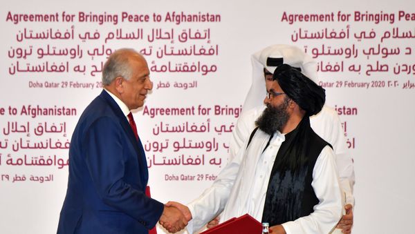 US Special Representative for Afghanistan Reconciliation Zalmay Khalilzad and Taliban co-founder Mullah Abdul Ghani Baradar shake hands after signing a peace agreement during a ceremony in the Qatari capital Doha on February 29, 2020 - Sputnik International