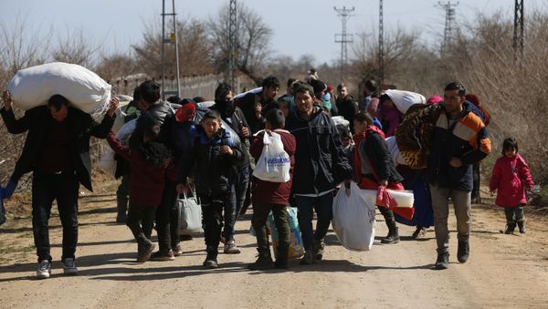 Migrants carrying their belongings walk near the Pazarkule gate in Edirne region, at the Turkish-Greek border on Tuesday, March 3, 2020 - Sputnik International