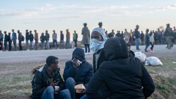 Migrants wait for a food distribution in front of the Pazarkule border crossing to Greece, on March 3, 2020, at Pzarkule in Edirne. Migrants wait for a food distribution in front of the Pazarkule border crossing to Greece, on March 3, 2020, at Pzarkule in Edirne. - Sputnik International