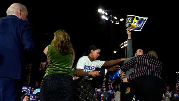 Democratic U.S. presidential candidate and former Vice President Joe Biden watches as anti-dairy industry protesters are pulled from the stage at his Super Tuesday night rally in Los Angeles, California, U.S., March 3, 2020. - Sputnik International