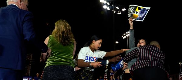 Democratic U.S. presidential candidate and former Vice President Joe Biden watches as anti-dairy industry protesters are pulled from the stage at his Super Tuesday night rally in Los Angeles, California, U.S., March 3, 2020. - Sputnik International