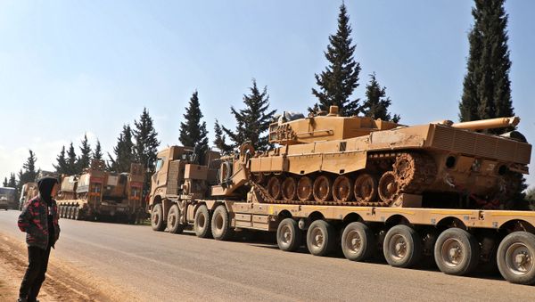 A boy looks at a convoy of Turkish military vehicles near the town of Hazano in the rebel-held northern countryside of Syria's Idlib province on March 3, 2020. A boy looks at a convoy of Turkish military vehicles near the town of Hazano in the rebel-held northern countryside of Syria's Idlib province on March 3, 2020. - Sputnik International