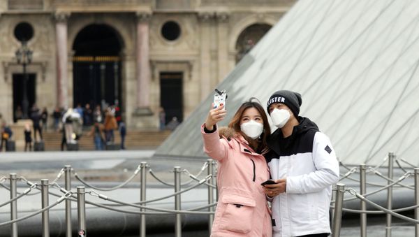 A couple wearing masks poses for a selfie near the Louvre Pyramid in Paris - Sputnik International