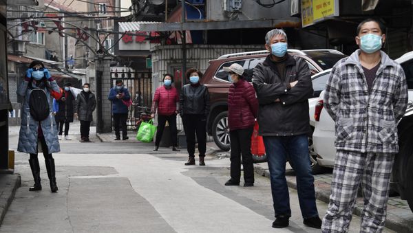 Residents line up to collect vegetables purchased through group orders at a residential area in Wuhan, the epicentre of the novel coronavirus outbreak, Hubei province, China March 5, 2020 - Sputnik International