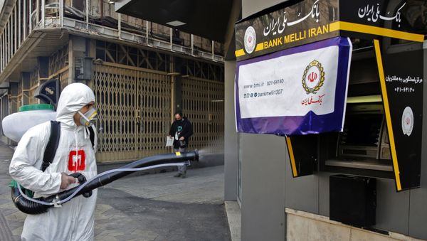 Iranian fire fighters and municipality workers disinfect a street in the capital Tehran for corona virus COVID-19 on March 5, 2020. - Sputnik International