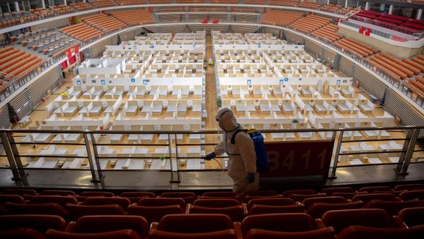 Worker in protective suit sprays disinfectant inside a closed makeshift hospital in Wuhan, the epicentre of coronavirus outbreak, in Hubei province, China March 8, 2020 - Sputnik International