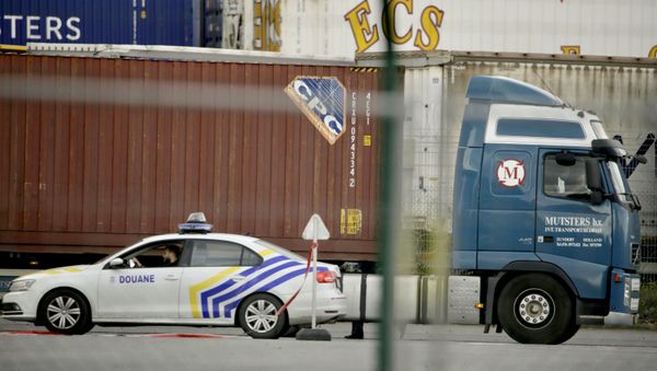 A customs police car parks next to a truck waiting to pass through a scanning tunnel at the Port of Zeebrugge, in Zeebrugge, Belgium, Thursday, Oct. 24, 2019. British police raided two sites in Northern Ireland and questioned a truck driver as they investigate the deaths of 39 people found in a truck container that they believe came from Zeebrugge and was then found at an industrial park in southeastern England. - Sputnik International