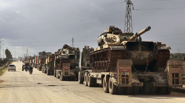 Turkish military convoy drives through the village of Binnish, in Idlib province, Syria, Saturday, Feb. 8, 2020 - Sputnik International