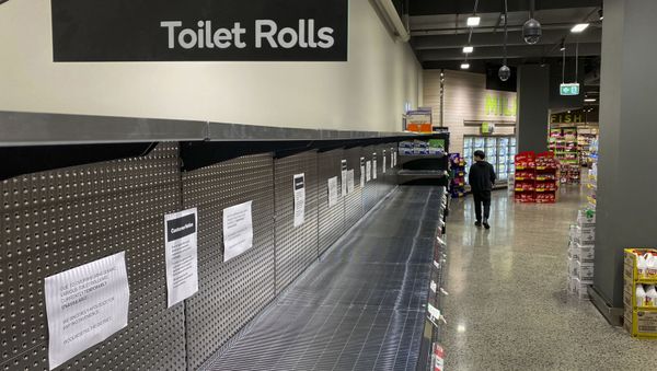 A shopper passes empty shelves usually stocked with toilet paper in a supermarket in Melbourne on March 5, 2020 - Sputnik International