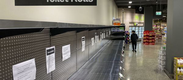 A shopper passes empty shelves usually stocked with toilet paper in a supermarket in Melbourne on March 5, 2020 - Sputnik International