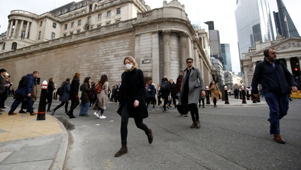 A woman wearing a protective face mask, following an outbreak of the coronavirus, walks in front of the Bank of England in London, Britain March 11, 2020 - Sputnik International