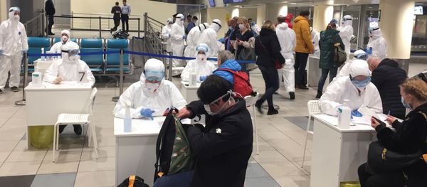 Russian officials and medical staff wearing protective gear check passengers as a preventive measure against the coronavirus (COVID-19) at Moscow's Domodedovo Airport Russian officials and medical staff wearing protective gear check passengers as a preventive measure against the coronavirus (COVID-19) at Moscow's Domodedovo Airport - Sputnik International