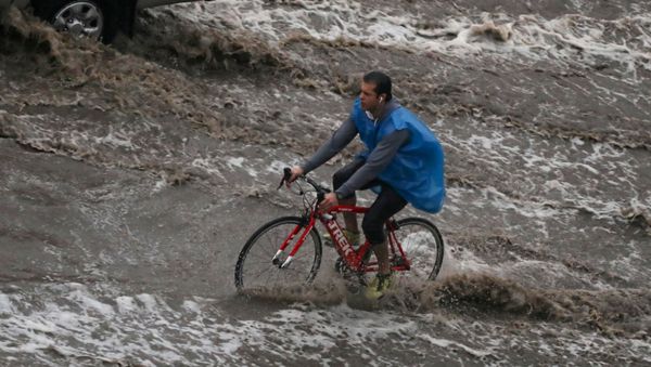 A man rides a bicycle during a thunderstorm and heavy rains in Cairo - Sputnik International