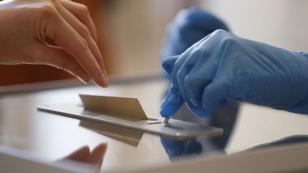 A voting volunteer using gloves opens the voting box for a vote during the first round of the municipal elections, in Strasbourg, eastern France, Sunday March 15, 2020. France is holding nationwide elections Sunday to choose all of its mayors and other local leaders despite a crackdown on public gatherings because of the new virus. For most people, the new coronavirus causes only mild or moderate symptoms. For some it can cause more severe illness.  - Sputnik International