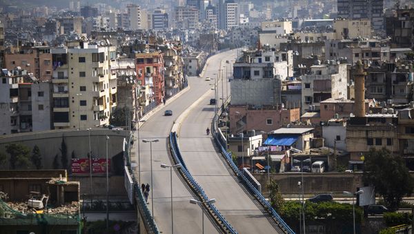 People walk on a highway that is almost empty of cars, east Beirut, Lebanon, Sunday, 15 March 2020. For most people, the new coronavirus causes only mild or moderate symptoms, such as fever and cough. For some, especially older adults and people with existing health problems, it can cause more severe illness, including pneumonia - Sputnik International