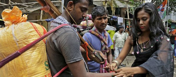 An Indian sex worker, right, ties a rakhi or a sacred thread on the wrist of a commuter as a symbolic gesture during Raksha Bandhan festival inside Sonagachhi, the biggest red light district in Kolkata, India, Monday, Aug. 7, 2017 - Sputnik International